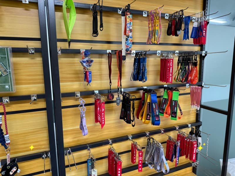 Assorted custom fabric keychains and lanyards displayed on wooden shelving