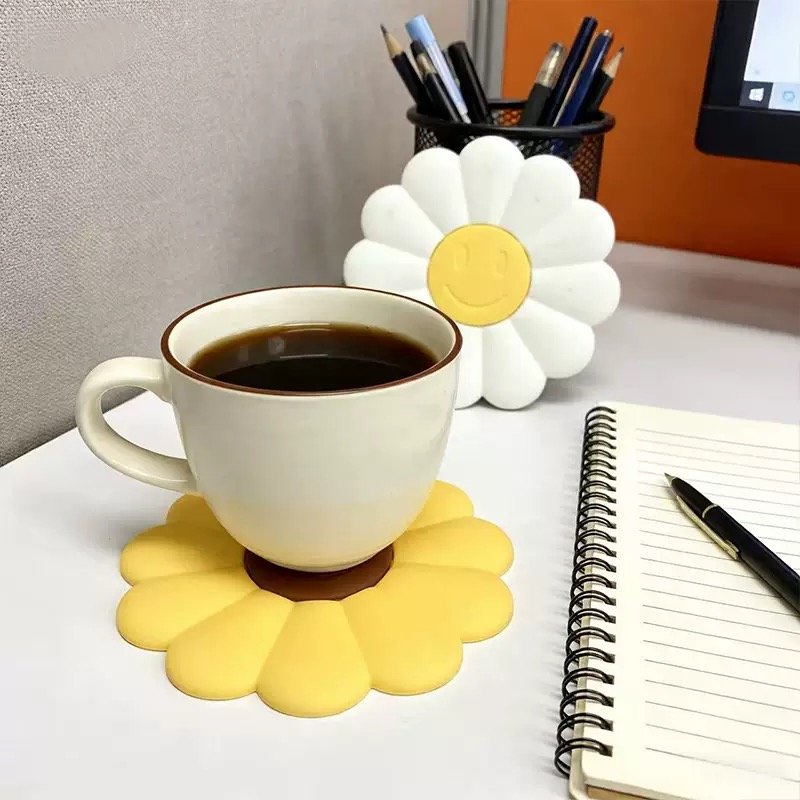 Daisy-shaped silicone coaster with smiley flower design