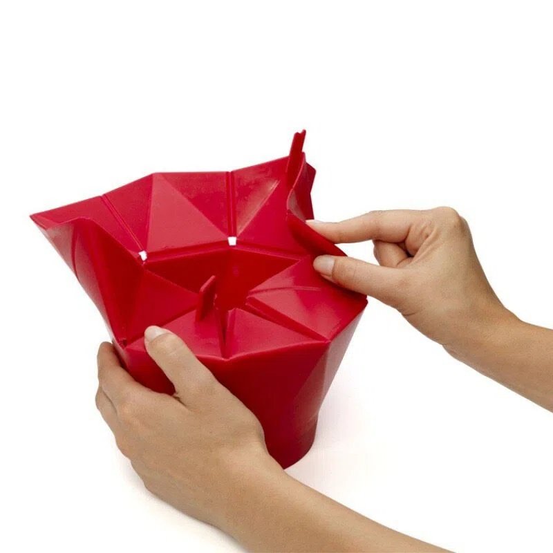 Hands adjusting red foldable Silicone Popcorn Bucket flaps