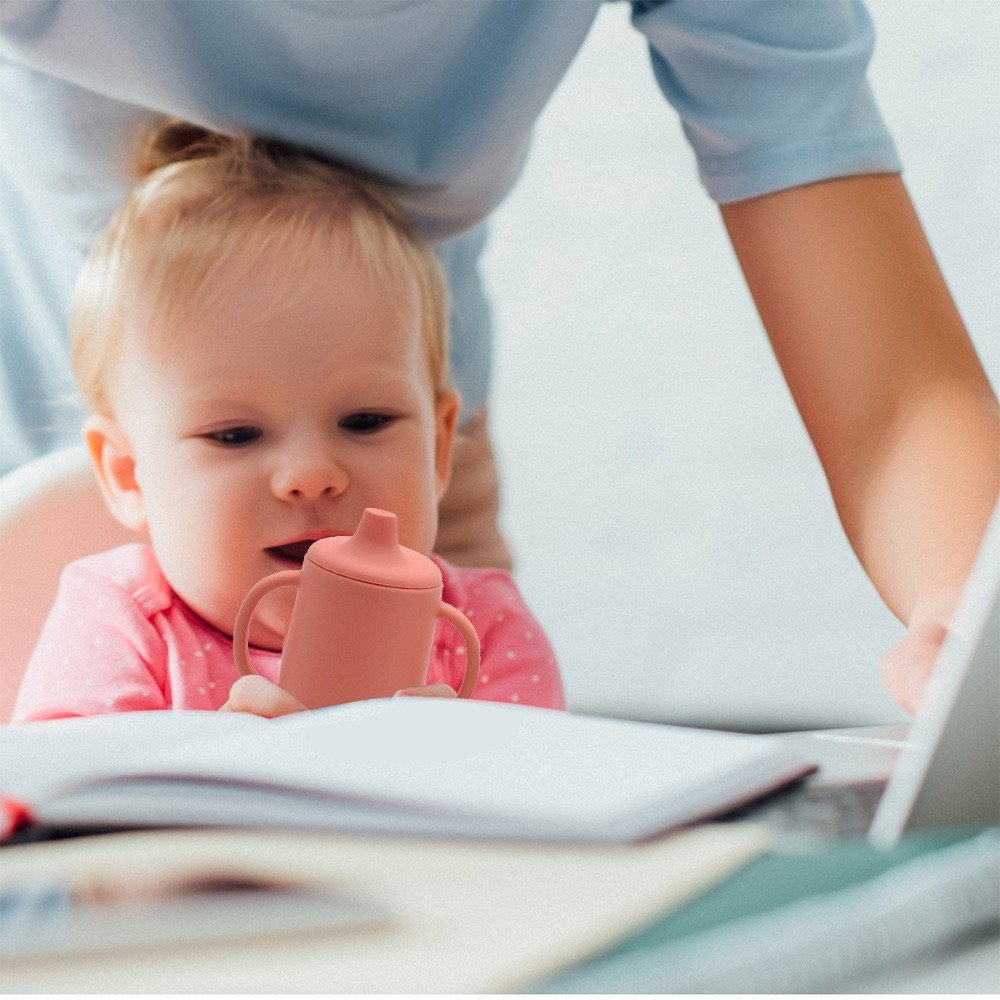 Toddler using soft silicone sippy cup during daily activity
